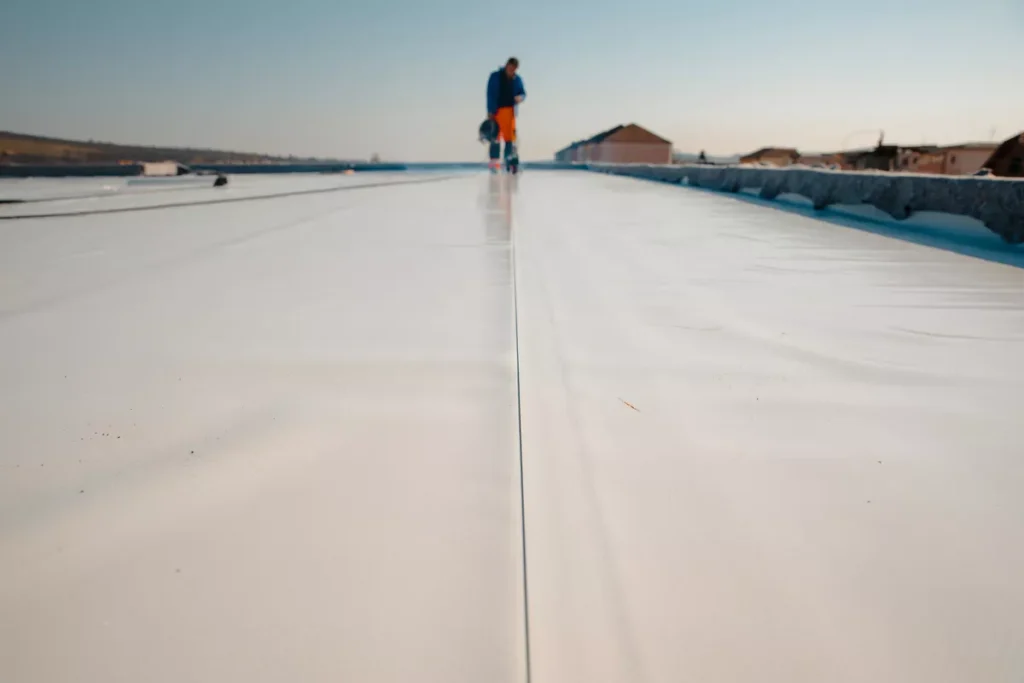 A long-shot view of a wide commercial roof in Scottsdale with a newly applied reflective white coating, promoting energy efficiency for modern industrial buildings.
