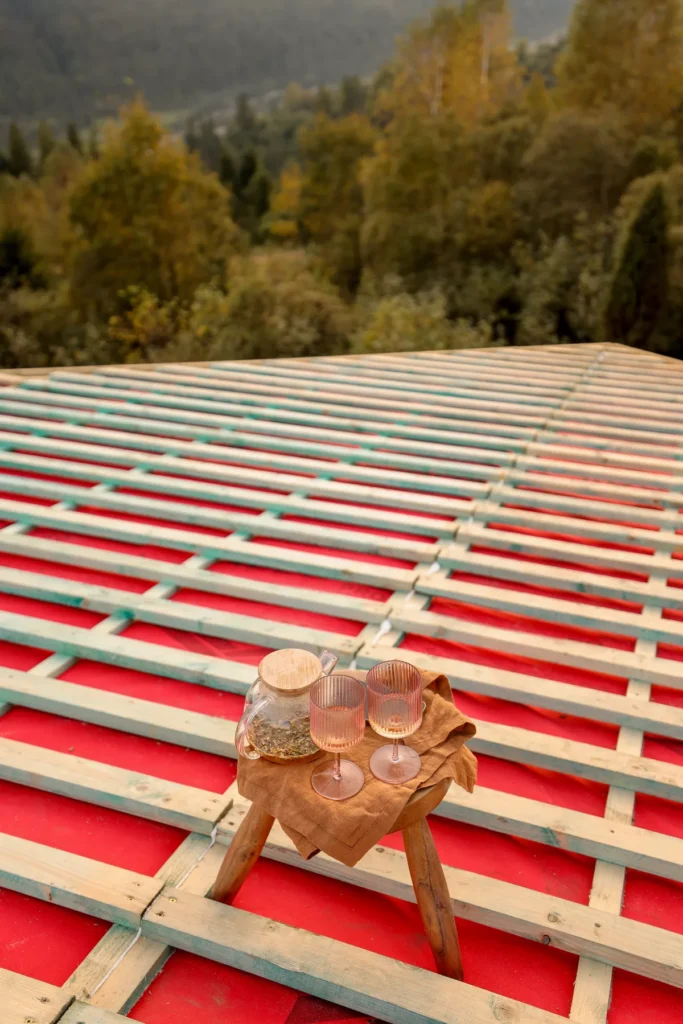 A peaceful outdoor tea setting on a wooden deck, representing the relaxation and comfort of a home protected by a high-quality roof.