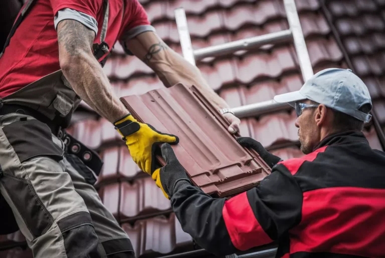 Two professional roofing contractors performing a terracotta tile roof repair on a residential home in Scottsdale, Arizona.
